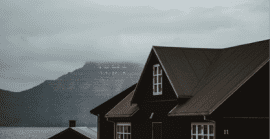 House in front of foggy hill and lake